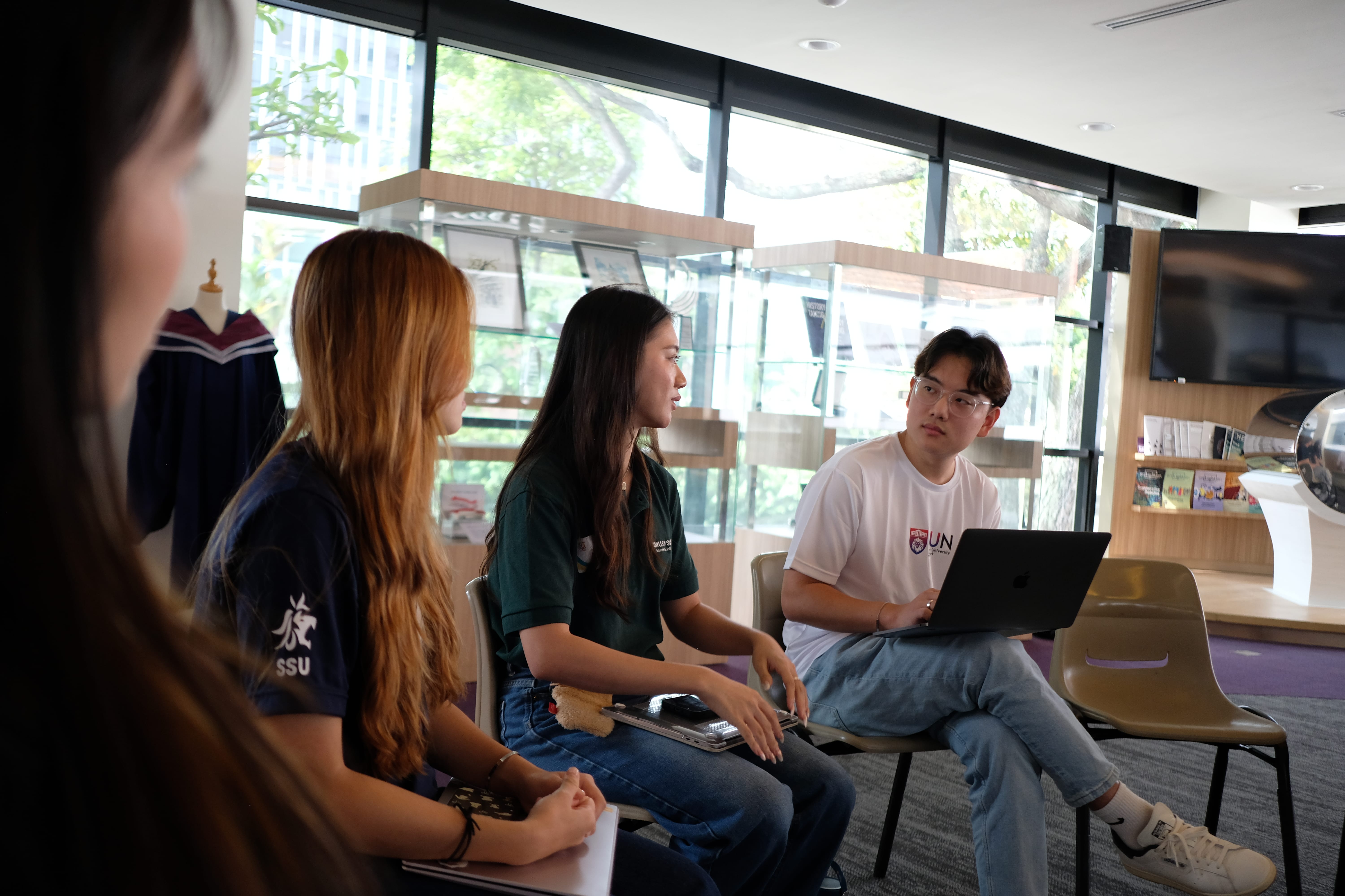 Students sit in chairs having a meeting